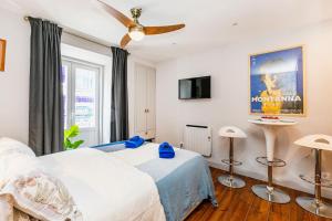 una camera con letto e ventilatore a soffitto di Cozy and perfect location Bairro Alto Chiado a Lisbona