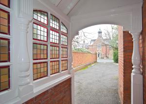 un arco que conduce a un edificio de ladrillo con ventanas en St Margaret's Hotel en Oxford