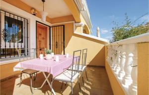 オリフエラ・コスタにあるBeautiful Apartment In Orihuela Costa With Kitchenのピンクのテーブルと椅子付きのバルコニー