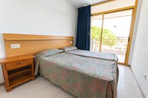 a bedroom with a bed and a table and a window at Catalonia Gardens in Salou