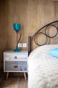 a bedroom with a bed and a blue flower on a dresser at Cosy studio in Stoupa in Stoupa
