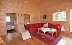 メレルードにあるHoliday home Anolfsbyn Mellerudのリビングルーム(赤いソファ、テーブル付)