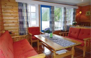 uma sala de estar com cadeiras vermelhas e uma mesa de madeira em Nice Home In Dirdal With Kitchen em Dirdal