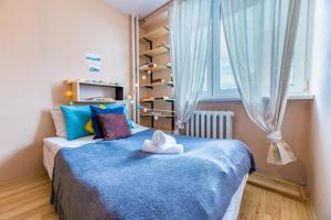 niewielka sypialnia z niebieskim łóżkiem i oknem w obiekcie Apartament Batorego 29 w Warszawie