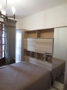 a bedroom with a bed with a television on the wall at Maison de vacances avec vue imprenable sur la mer in Calcatoggio