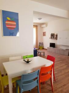 a dining room with a white table and colorful chairs at casa S Leonardo in Crotone