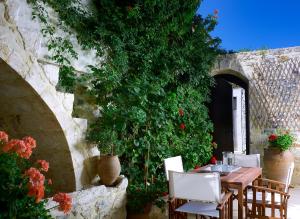 een tafel en stoelen in een patio met een plant bij Agrielia Villa in episkopi-heraklion