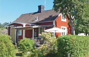 a red house with an umbrella in front of it at Awesome Home In Sjtorp With Wifi in Sjötorp