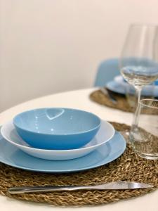 une table avec un bol bleu et des assiettes sur une table dans l'établissement Nesh House, à Syracuse