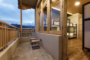 a balcony with a bench and a view of the ocean at HITCHHIKERS HOSTEL LADAKH in Leh