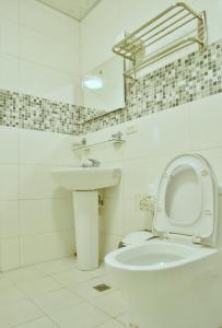 a white bathroom with a toilet and a sink at 啾開心包棟 一天接一組客人 in Xiaoliuqiu