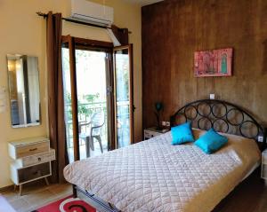 a bedroom with a bed with blue pillows on it at Cosy studio 1 in Stoupa in Stoupa