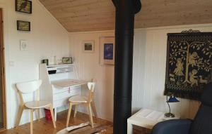 a room with a stove with a table and chairs at Nice Home In senfjorden With 3 Bedrooms in Vollen