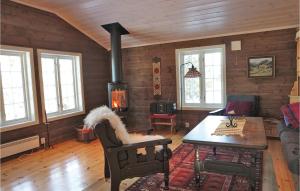 SjusjøenにあるBeautiful Home In Sjusjen With 3 Bedroomsのリビングルーム(暖炉、テーブル付)