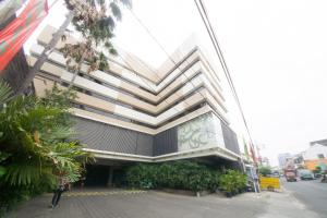 a person standing outside of a building on a street at New Grand Park Hotel in Surabaya