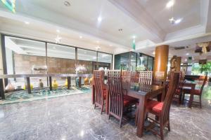 a dining room with a table and chairs at New Grand Park Hotel in Surabaya
