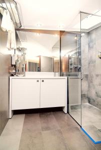 La salle de bains est pourvue d'une douche et d'un comptoir blanc. dans l'établissement Hotel Trianon, à Bucarest