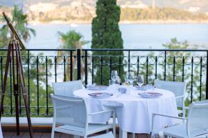 a white table and chairs with a view of the water at Hotel Majestic in Budva