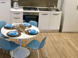 a kitchen with a white table and blue chairs at Nesh House in Syracuse