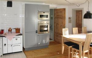 a kitchen with a white refrigerator and a table at Cozy Home In Skillingaryd With Wifi in Nydala