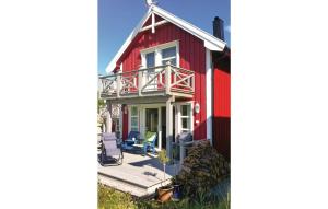 a red house with a deck and a patio at Nice Home In senfjorden With 3 Bedrooms in Vollen