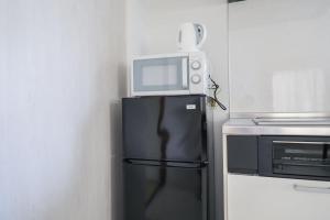 een magnetron bovenop een koelkast in een keuken bij Seto Building in Osaka +82 foto's