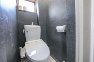 een badkamer met een wit toilet en een raam bij Seto Building in Osaka