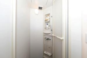 een kleine badkamer met een douche en een deur bij Seto Building in Osaka