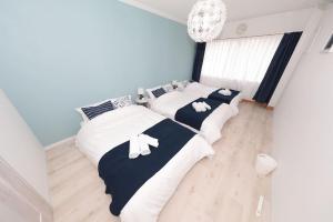 two beds in a room with white and blue at Seto Building in Osaka