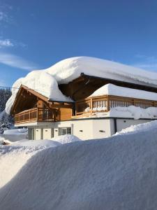 een huis bedekt met sneeuw met een berg sneeuw bij Appartement Meier in Seefeld in Tirol