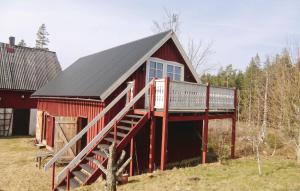a red barn with a deck on the side of it at Beautiful Home In Vilshult With Kitchen in Vilshult