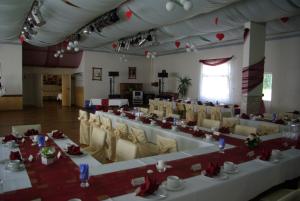 un gran salón de banquetes con mesas y sillas blancas en Hotel Güldene Gabel, en Unterwellenborn