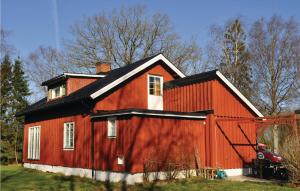 梅勒呂德的住宿－Lovely Home In Mellerud With Kitchen，黑色屋顶的红色谷仓