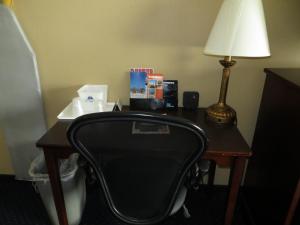 a desk in a hotel room with a lamp and a chair at Inn at Bayshore in San Mateo