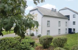 NoertrangeNice Apartment In Noertrange With Wifi的一栋白色的房子,前面有一棵树