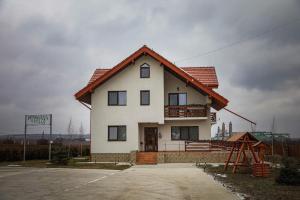 une grande maison blanche avec un toit rouge dans l'établissement Pensiunea Lucian, à Bălţaţi