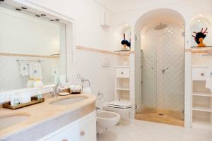 uma casa de banho com um chuveiro, um lavatório e um WC. em Villa Boheme Exclusive Luxury Suites em Positano