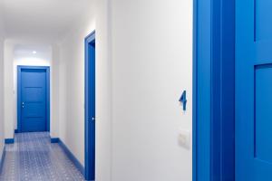 two blue doors in a hallway with a tile floor at Hotel Mignon Meublè in Sorrento