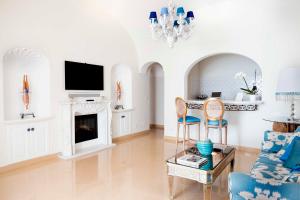 Il comprend un salon avec une cheminée et une télévision. dans l'établissement Villa Boheme Exclusive Luxury Suites, à Positano