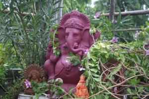 a pink statue in a garden with plants at Bed & Chai Guesthouse in New Delhi