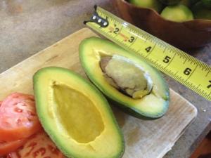 un tagliere con un avocado affettato e un nastro di misura di Heavenly Hana Paradise a Hana