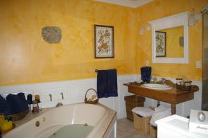 a bathroom with a bathtub and a painting on the wall at Country Encounters Accommodations in Coleman