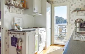 a kitchen with a washer and dryer and a balcony at Three-Bedroom Holiday Home In Brastad in Brastad