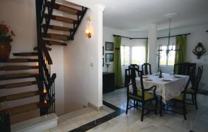 a dining room with a table and a staircase at Stunning Apartment In Calahonda With 3 Bedrooms, Wifi And Outdoor Swimming Pool in La Cala de Mijas