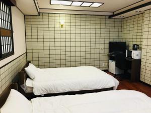 Vuode tai vuoteita majoituspaikassa Guesthouse & Hotel RA Kagoshima