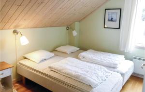 MollösundにあるAmazing Home In Mollsund With 3 Bedrooms And Wifiの木製天井のベッドルーム1室(ベッド2台付)