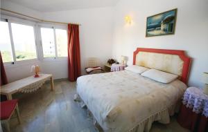 a bedroom with a large bed and two windows at Beautiful Apartment In Calahonda in La Cala de Mijas