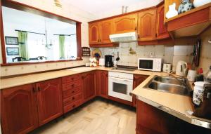 a kitchen with wooden cabinets and a sink at Beautiful Apartment In Calahonda in La Cala de Mijas