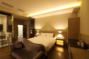 a hotel room with a bed and a couch at Yu Chun Hotel in Taichung
