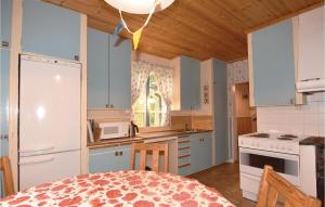 SutterhöjdenにあるHoliday Home Brattforsheden Molkomの白いキャビネットとテーブル付きのキッチンが備わります。